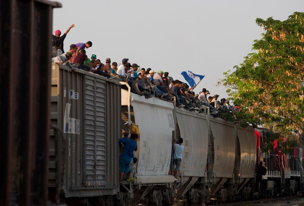 ARCHIVO - Migrantes centroamericanos montados sobre un tren de carga en su ruta hacia la...